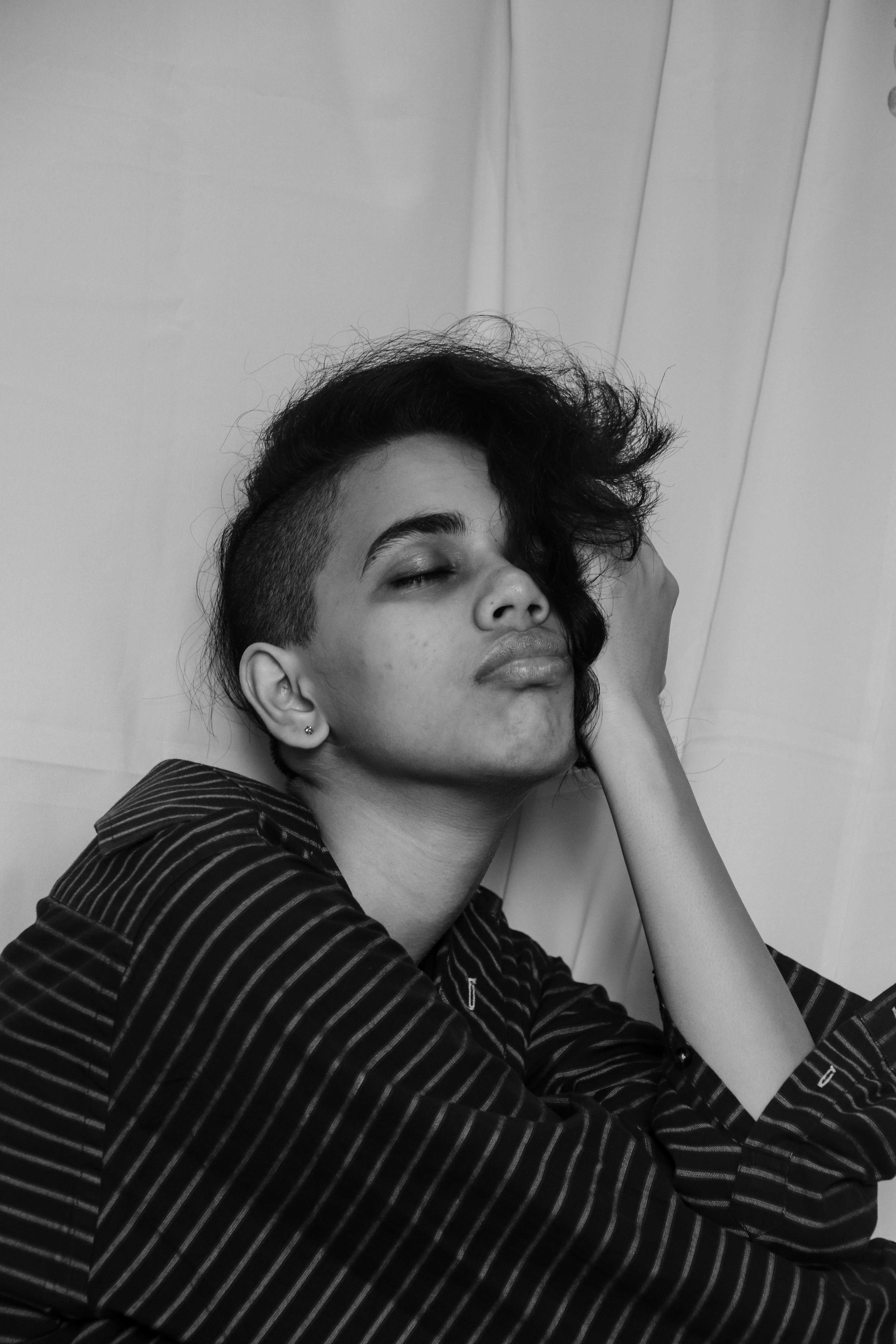 Monochrome portrait of a woman with an undercut hairstyle wearing a striped shirt
